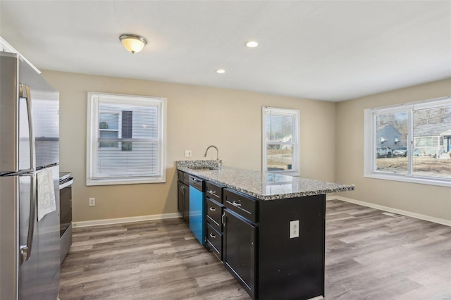 kitchen with stainless steel appliances, light wood-type flooring, a peninsula, and baseboards