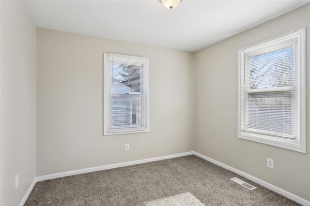 carpeted empty room with visible vents and baseboards