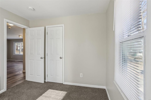 unfurnished bedroom featuring carpet floors, a closet, and baseboards