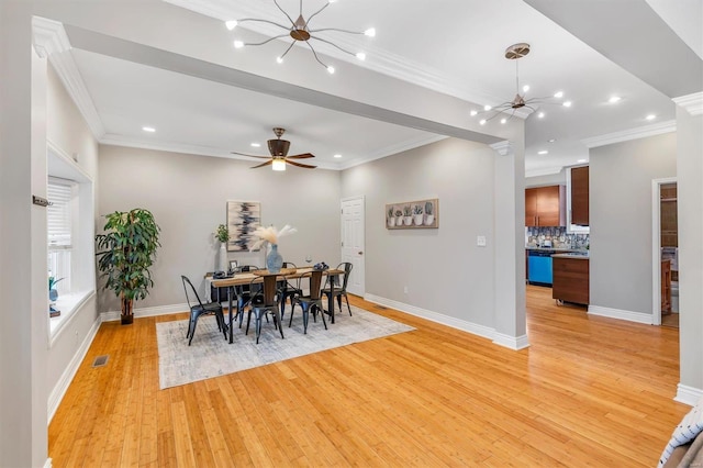 dining area featuring light wood-style flooring, visible vents, and crown molding