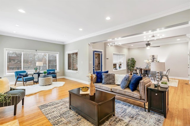 living room featuring light wood-style floors, baseboards, and ornamental molding