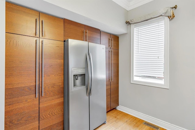 kitchen with baseboards, visible vents, a wealth of natural light, and stainless steel fridge with ice dispenser