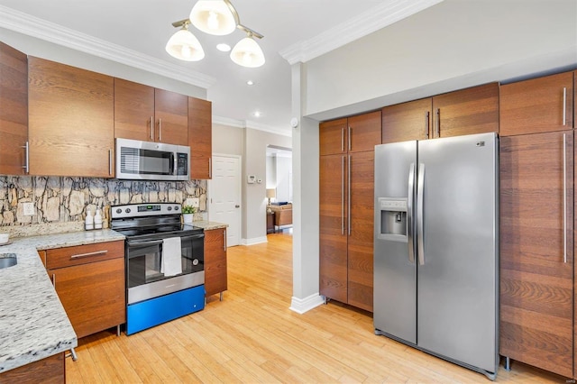 kitchen featuring crown molding, stainless steel appliances, tasteful backsplash, light wood-style flooring, and baseboards