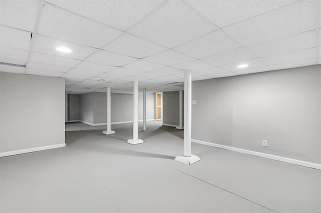 finished below grade area featuring a paneled ceiling, baseboards, and recessed lighting