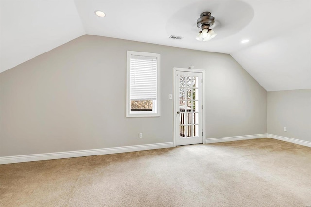 additional living space featuring lofted ceiling, carpet flooring, visible vents, and a ceiling fan