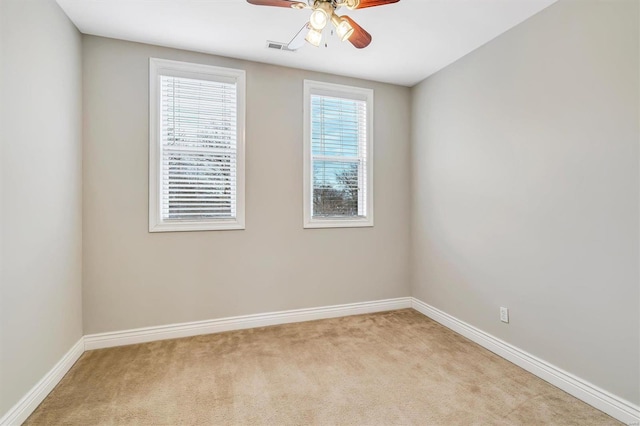 empty room featuring light colored carpet, visible vents, and baseboards