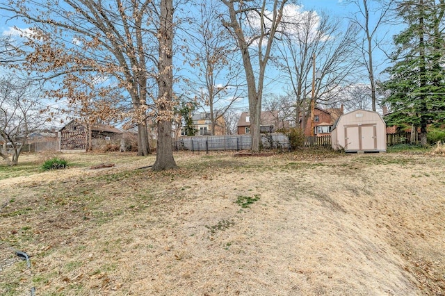 view of yard featuring an outbuilding, a storage shed, and fence