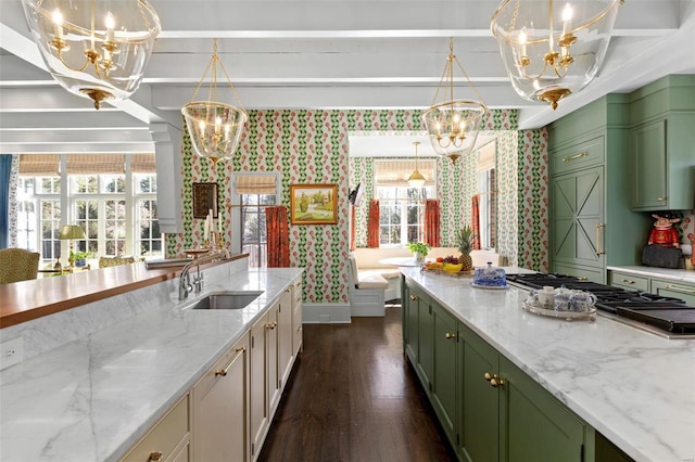 kitchen with wallpapered walls, green cabinets, an inviting chandelier, and a sink