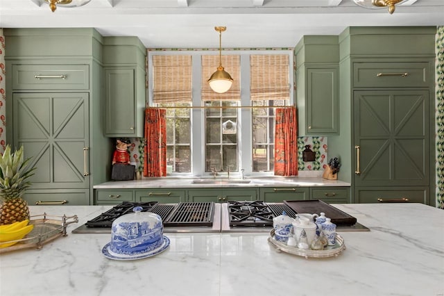 interior space featuring a sink, decorative light fixtures, light stone countertops, and green cabinetry