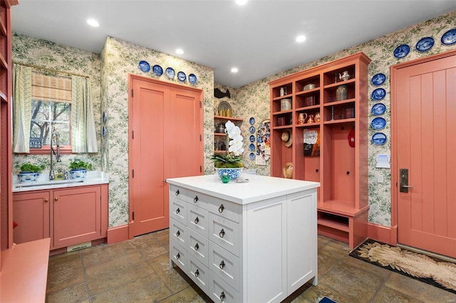 interior space with stone tile flooring, wallpapered walls, light countertops, and open shelves