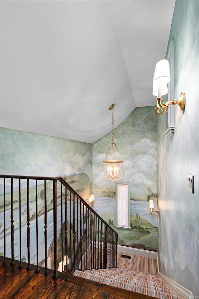 stairway with lofted ceiling and a chandelier