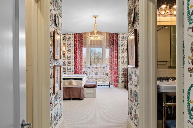 spacious closet featuring a notable chandelier, carpet, and a sink