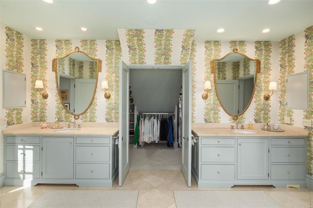 bathroom with wallpapered walls, two vanities, and a sink