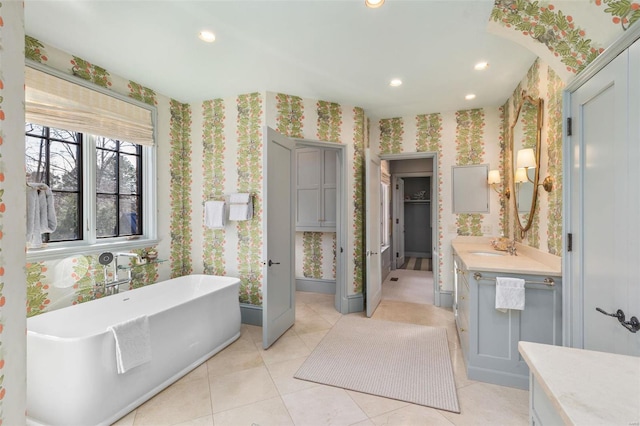 full bathroom featuring a freestanding tub, wallpapered walls, recessed lighting, tile patterned flooring, and vanity