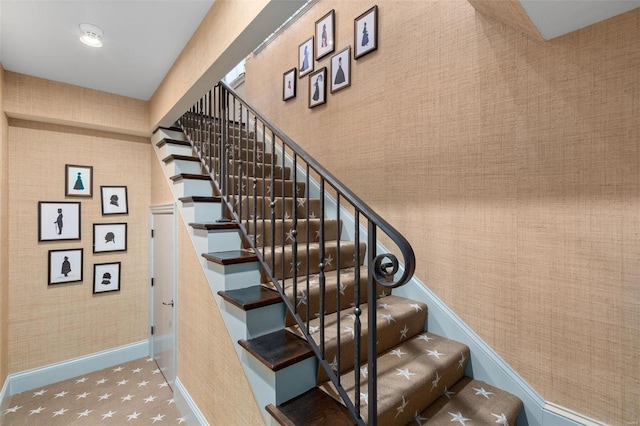 stairway with carpet flooring, wallpapered walls, and baseboards