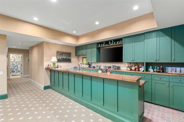 kitchen featuring butcher block counters, recessed lighting, and green cabinetry