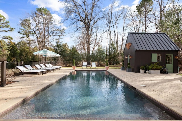 view of swimming pool featuring fence, an exterior structure, an outdoor structure, a fenced in pool, and a patio area