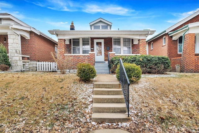 bungalow-style house with a porch and brick siding