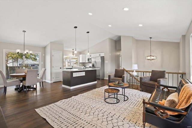 living room featuring dark wood finished floors, vaulted ceiling, and a notable chandelier