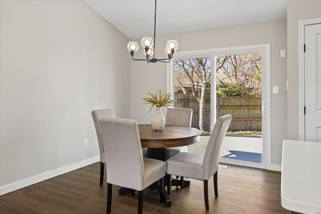 dining space with a notable chandelier, wood finished floors, and baseboards