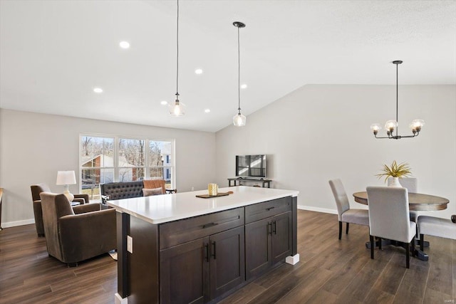 kitchen featuring vaulted ceiling, light countertops, dark wood-style flooring, and a center island