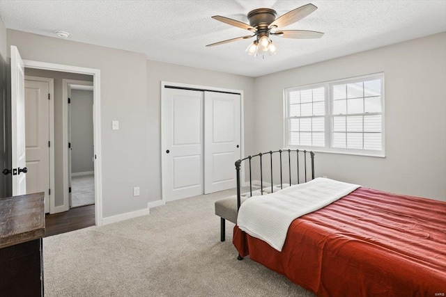 bedroom featuring a closet, carpet flooring, a textured ceiling, and baseboards