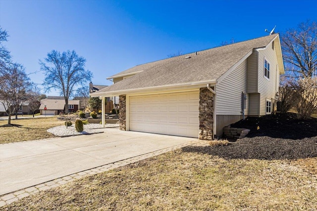 view of side of property with stone siding, roof with shingles, driveway, and an attached garage