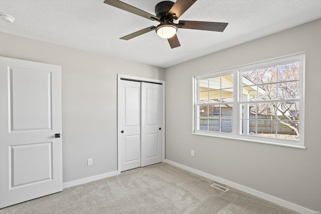 unfurnished bedroom with carpet, baseboards, and a textured ceiling