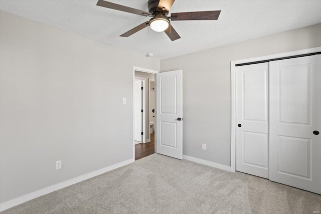 unfurnished bedroom featuring a textured ceiling, a ceiling fan, baseboards, a closet, and carpet