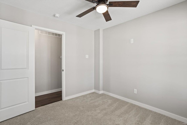 unfurnished bedroom featuring visible vents, baseboards, a ceiling fan, carpet, and a textured ceiling