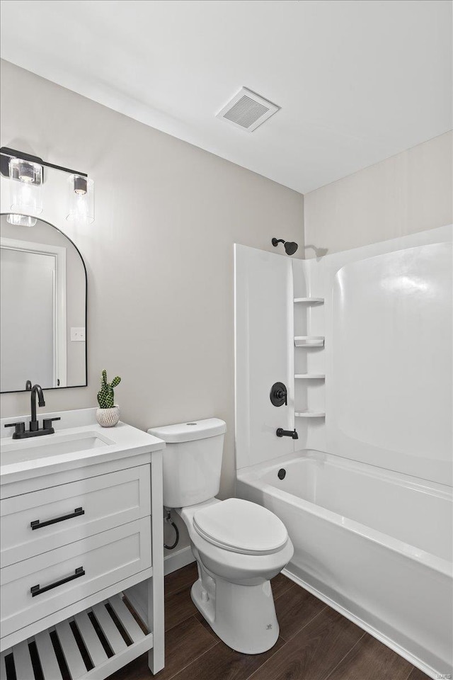 full bathroom featuring toilet, visible vents, wood finished floors, and vanity