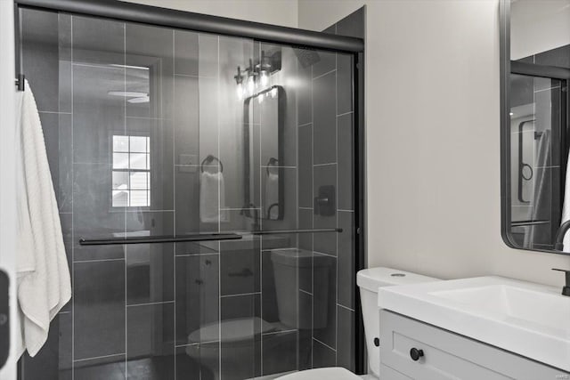 bathroom with a shower stall, toilet, and vanity