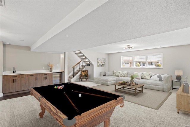 rec room with carpet floors, beverage cooler, visible vents, and a textured ceiling