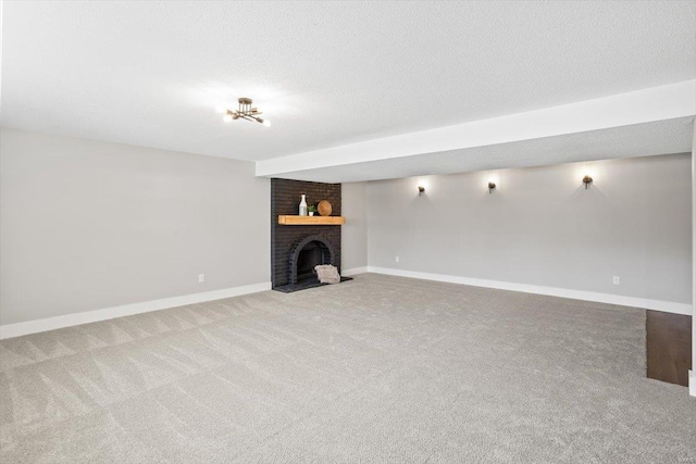 unfurnished living room featuring a textured ceiling, carpet floors, a brick fireplace, and baseboards