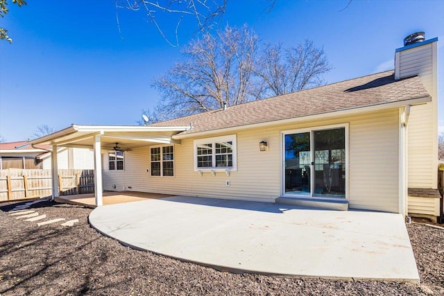 rear view of house with roof with shingles, a chimney, a patio area, fence, and ceiling fan