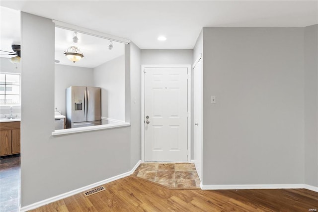 interior space with wood finished floors, visible vents, baseboards, a ceiling fan, and track lighting