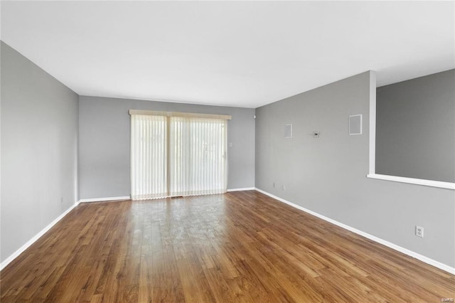 empty room with baseboards and wood finished floors