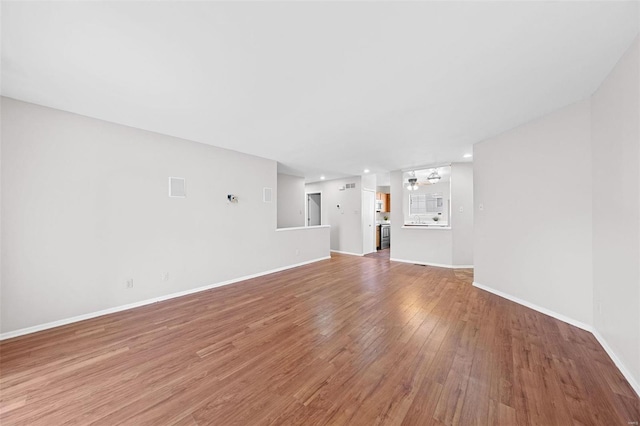 unfurnished living room featuring light wood-style flooring and baseboards