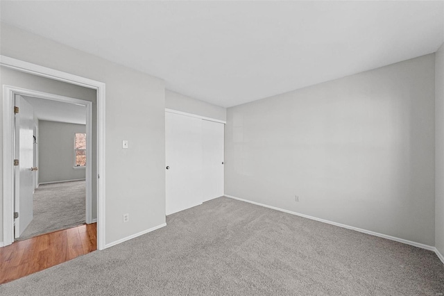 unfurnished bedroom with carpet, baseboards, and a closet