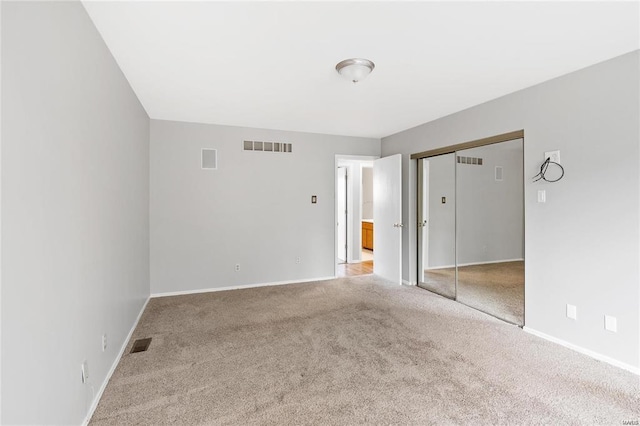 carpeted empty room with visible vents and baseboards