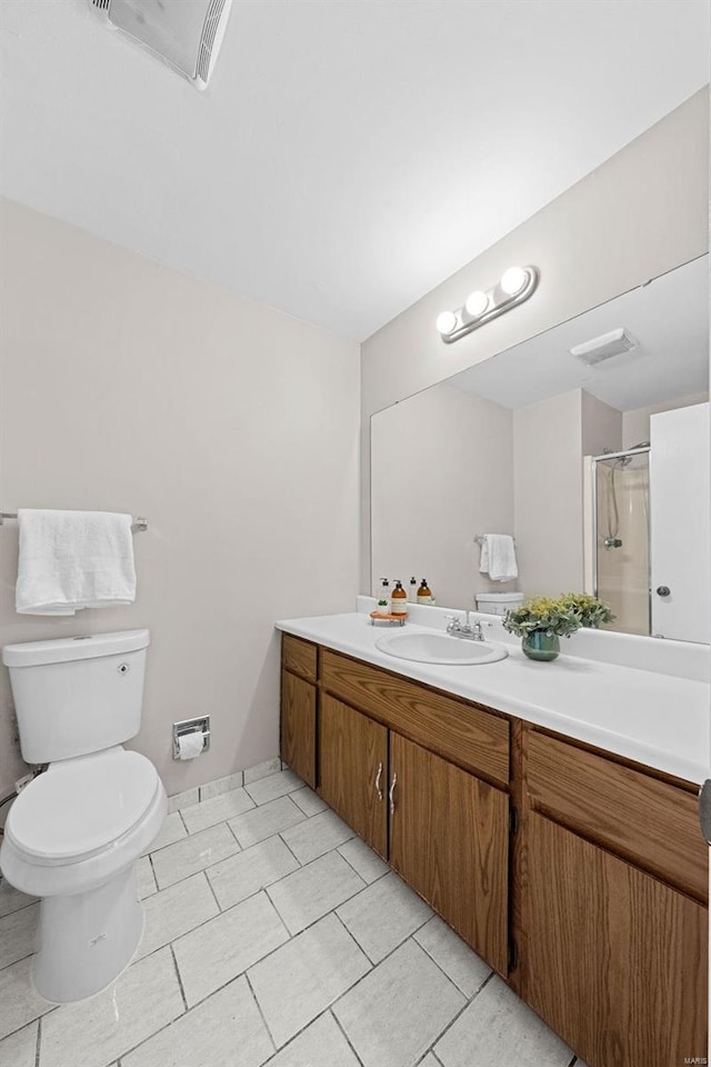 full bathroom with a shower with door, visible vents, toilet, vanity, and tile patterned flooring