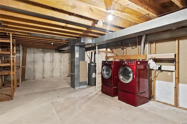 unfinished below grade area featuring washer and dryer, water heater, and heating unit