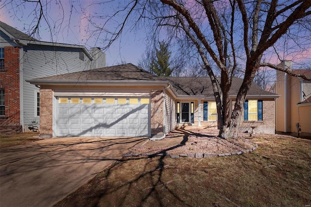 view of front of house featuring a garage, brick siding, driveway, and a chimney