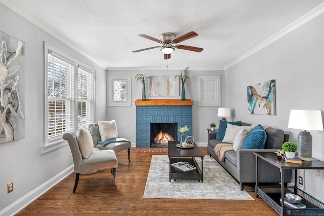 living area featuring ornamental molding, a brick fireplace, baseboards, and wood finished floors