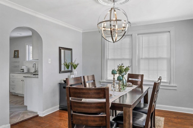 dining room with arched walkways, dark wood-style flooring, and baseboards