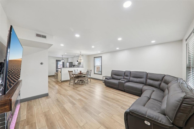 living area with light wood-style floors, baseboards, visible vents, and recessed lighting