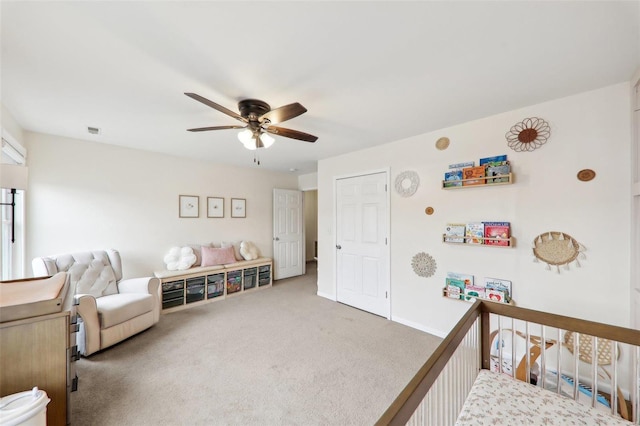 carpeted bedroom with a ceiling fan, a nursery area, visible vents, and baseboards