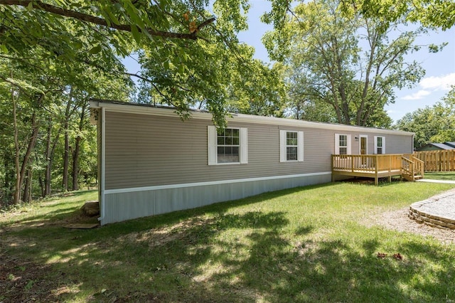 rear view of property featuring a deck and a lawn