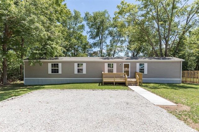 manufactured / mobile home featuring a front yard, fence, and a deck