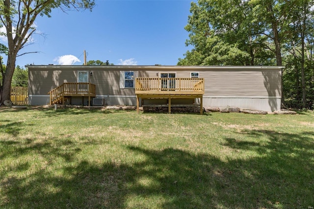 back of house featuring cooling unit, a deck, and a lawn